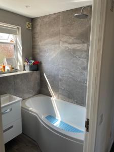 a bath tub in a bathroom with a shower at 4 bed Family home in Bicester in Bicester