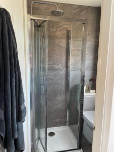 a shower with a glass door in a bathroom at 4 bed Family home in Bicester in Bicester