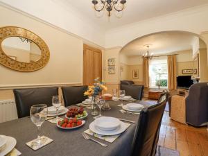 a dining room with a table and a mirror at Green Gate Cottage in Southwold