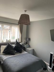 a bedroom with a bed with black pillows and a lamp at 4 bed Family home in Bicester in Bicester