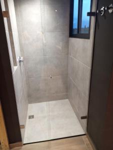 um chuveiro com uma porta de vidro na casa de banho em Finca 3 - Dakeva em El Peñol