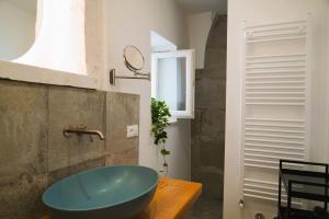 ein Badezimmer mit einer blauen Badewanne auf einem Holztisch in der Unterkunft Palazzo Lorizzo - nel CUORE di OSTUNI in Ostuni