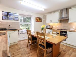 a kitchen with a wooden table and chairs at 2 Isygraig in Corris