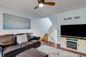 a living room with a leather couch and a flat screen tv at Across the Street from Beach Access-Pool & Garage-Sleeps 6-Sea Castle 12 in Fernandina Beach