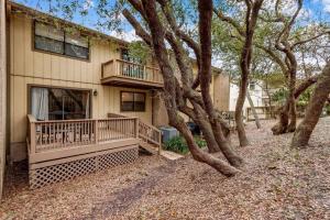 a house with a balcony and trees in front of it at Across the Street from Beach Access-Pool & Garage-Sleeps 6-Sea Castle 12 in Fernandina Beach