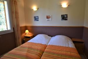 1 dormitorio con 1 cama y 2 cuadros en la pared en VAUJANYLOCATIONS - ROCHES GRANDES 47 en Vaujany