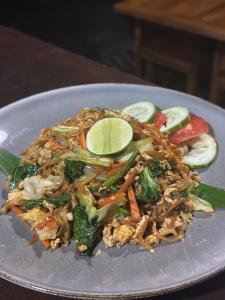 a plate of food with noodles and vegetables at The babakan accommodations in Sidemen