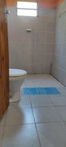 a bathroom with a toilet and blue mats on the floor at Hospedaje Emma in Ayolas