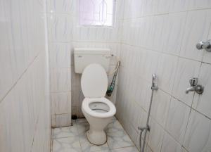a small bathroom with a toilet with a window at Namaskar Lodge and Homestay in Guwahati