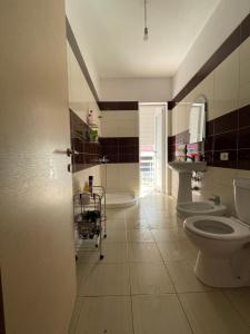 uma casa de banho com 2 WC e um lavatório em Panoramic View Apartment em Përmet