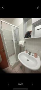 a bathroom with a white sink and a shower at NaCity Holiday Home in Naples