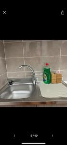 a kitchen sink with a green bottle on a shelf at NaCity Holiday Home in Naples