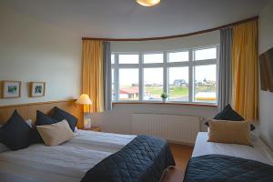 pokój hotelowy z 2 łóżkami i dużym oknem w obiekcie Adventure Hotel Hellissandur w mieście Hellissandur