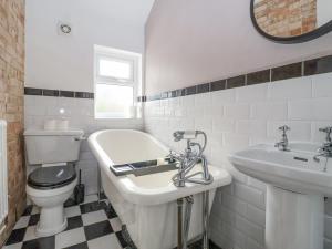 a bathroom with a tub and a toilet and a sink at Sunrise House in Lowestoft +28 photos