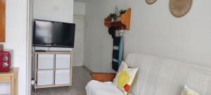 a living room with a white couch and a flat screen tv at DALIUS HOME - Apartment with pool near the dunes of Maspalomas in Playa del Ingles