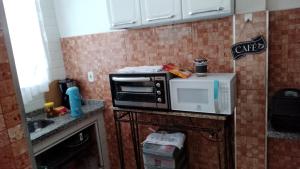 La cocina está equipada con horno tostadora y microondas. en Casa Temporada Privativa RJ en Iguaba Grande