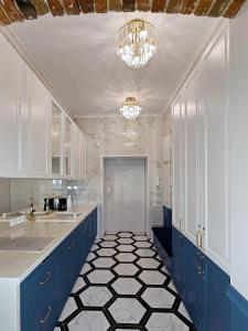 a kitchen with blue cabinets and a black and white tile floor at Dream Apartments Kielce Centrum in Kielce