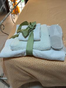 a pile of towels with a green bow on a table at Casasofé in Vico del Gargano