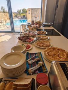 a buffet with plates of food on a counter at Sea Holly Gozo in Nadur