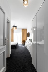 Cette chambre dispose d'un couloir avec un lit et d'une salle de bains. dans l'établissement POŁUDNIK PARK Boutique Hotel Conference&SPA, à Stargard