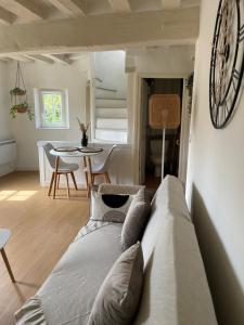 a living room with a couch and a clock on the wall at Charmant Duplex - Parking inclus - Au bord de l'Eure in Chartres