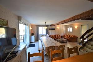 ein Wohnzimmer mit einem Tisch und einem Sofa in der Unterkunft VAUJANYLOCATIONS - Roches Grandes 49 in Vaujany