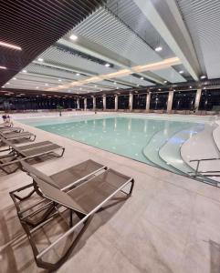 a large swimming pool with chairs in a building at Alin's home in Ocna-Mureşului