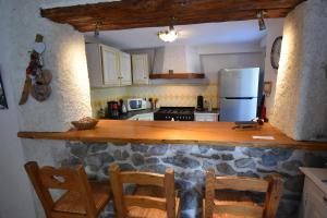 eine Küche mit einer Theke mit Stühlen und einem Kühlschrank in der Unterkunft VAUJANYLOCATIONS - Roches Grandes 49 in Vaujany