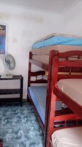 2 literas en una habitación con lámpara y mesa en Casa Mongagua en Mongaguá