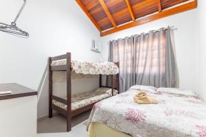 1 dormitorio con litera y ventana en Sobrado 1 Quadra e Meia do Mar- Praia de Bombinhas - 2 dorms até 6 pessoas, en Bombinhas