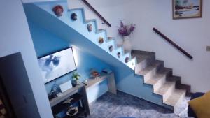 a living room with a blue staircase with a tv at Casa Mongagua in Mongaguá