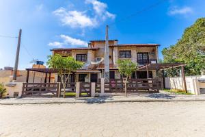 una casa con una valla delante de ella en Sobrado 1 Quadra e Meia do Mar- Praia de Bombinhas - 2 dorms até 6 pessoas, en Bombinhas