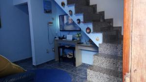 a room with a staircase with a desk and a stair case at Casa Mongagua in Mongaguá