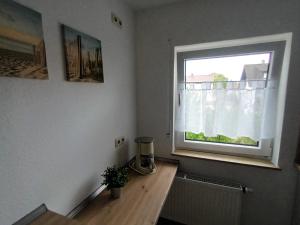 a room with a wooden table and a window at Apartment Schwalbenweg - Günstige Langzeitvermietung in Gelnhausen