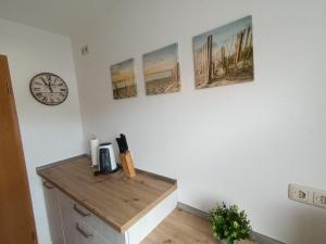 a room with a desk with a clock on the wall at Apartment Schwalbenweg - Günstige Langzeitvermietung in Gelnhausen