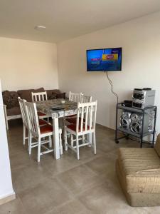a living room with a table and chairs and a television at Duplex nuevo Playa Unión in Playa Unión