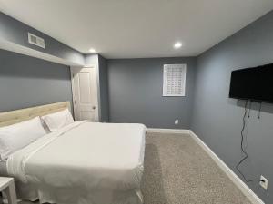 a bedroom with a bed and a flat screen tv at The Blue House! Modern+ Rooftop deck+ Parking in Baltimore