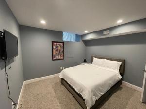 a bedroom with a bed and a flat screen tv at The Blue House! Modern+ Rooftop deck+ Parking in Baltimore