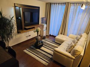 uma sala de estar com dois sofás e uma televisão em Departamento Amoblado - 4 Personas - Centro Viña del Mar em Viña del Mar