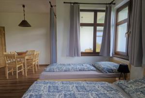 2 Betten in einem Zimmer mit einem Tisch und einem Fenster in der Unterkunft Ubytování U Bohouše in Horní Radouň