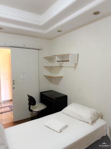 um quarto com uma cama, uma secretária e uma cadeira em Pousada Vale do Rubi em Londrina