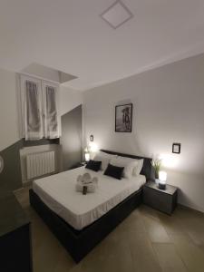 una camera da letto con un grande letto con lenzuola e cuscini bianchi di Milan 3Suites a Milano
