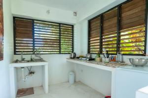 una cocina con encimera y 2 lavabos y ventanas en Coyaba 1 Bedroom Unit - Embrace Tranquility in the Hanover Countryside, en Orange Bay