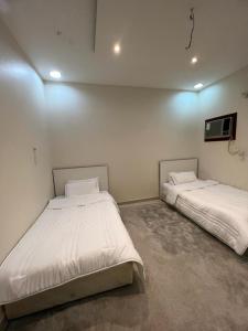 twee bedden in een kamer met witte muren bij Private Family's Apartment in Obhor