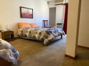 a bedroom with a bed and a chair at KAD Alojamiento in Mendoza