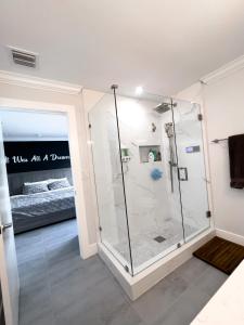 a glass shower in a room with a bed at House Of Art - Luxury Villa with Pool & Jacuzzi! in Tamiami