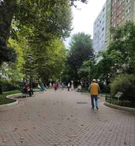 a man walking down a brick walkway in a park at Apartamento céntrico La Morada Santanderina in Santander