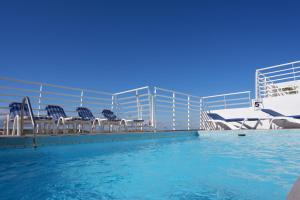 a swimming pool with chairs on a cruise ship at Shamrock Apartments in St Paul's Bay
