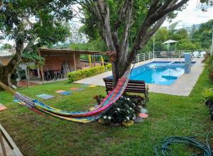een hangmat hangend aan een boom naast een zwembad bij FINCA YAJARI in Papagalleros
