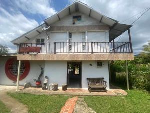 uma casa branca com um alpendre e uma varanda em FINCA YAJARI em Papagalleros